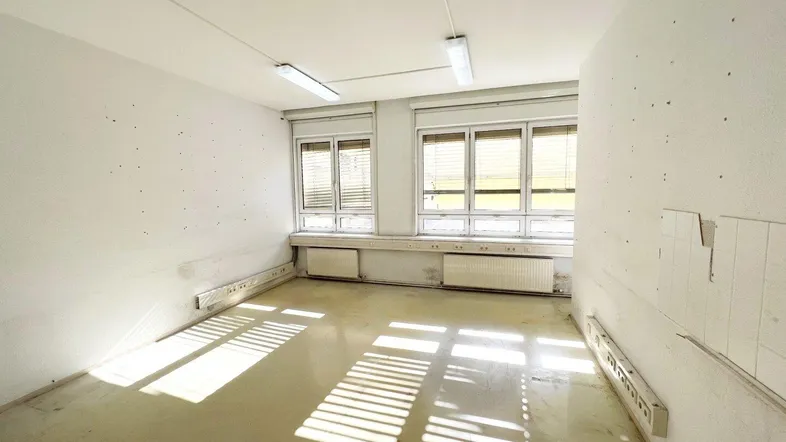 Heller Büroraum mit großen Fenstern, Jalousien und viel natürlichem Licht, bereit zur individuellen Gestaltung.