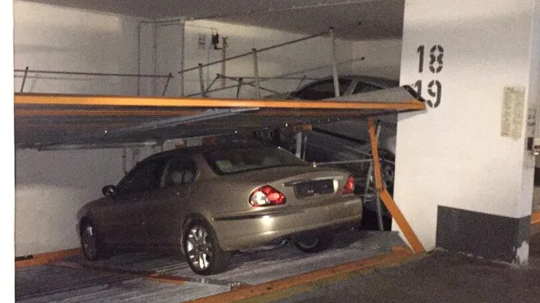 Tiefgarage mit einem Doppelparker-System für zwei Fahrzeuge, beleuchtet und funktional.