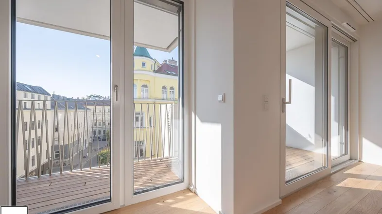 Heller Innenraum mit Holzboden und Zugang zu einem Balkon mit Stadtblick.