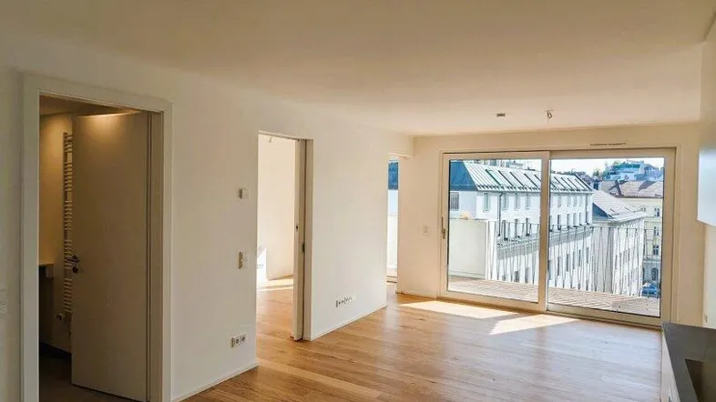 Helles Wohnzimmer mit Parkettboden, großen Schiebetüren und Blick auf die Stadt.