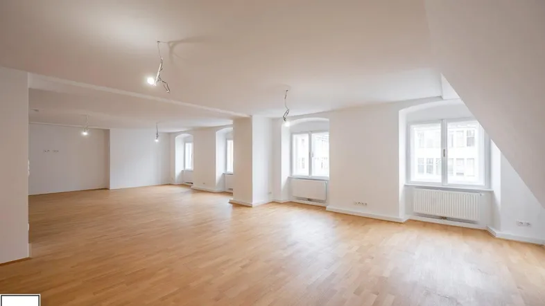 Geräumiger, heller Wohnbereich mit Parkettboden und mehreren Fenstern, bereit zur individuellen Gestaltung.
