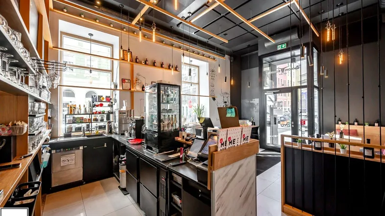Moderne Theke mit Kaffeemaschine, Zapfanlage und Blick auf die Straße, ideal für den Kundenbereich.