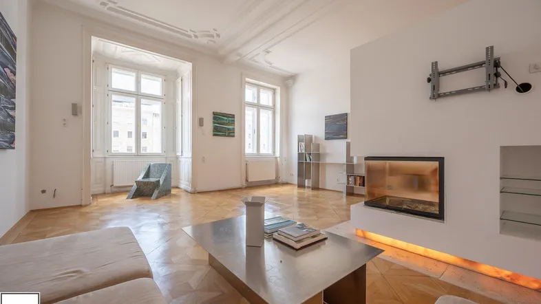 Helles Wohnzimmer mit Fischgrätparkett, Stuckdecke und modernem Kamin, durchflutet von natürlichem Licht.