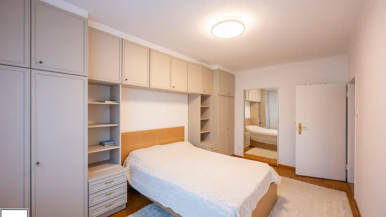 Gemütliches Schlafzimmer mit maßgefertigten Einbauschränken und hellem Holzbett.