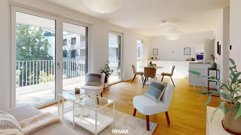 Moderner offener Wohn-Essbereich mit heller Holzboden, großen Fenstern und Zugang zum Balkon.