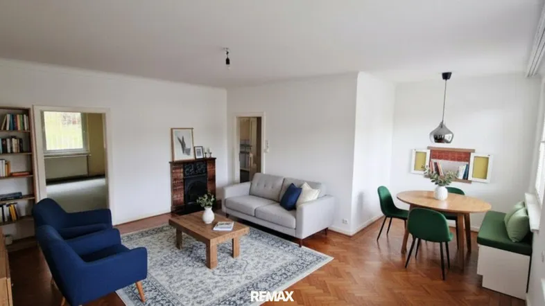 Helles Wohn- und Esszimmer mit Parkettboden, Kamin und moderner Einrichtung.