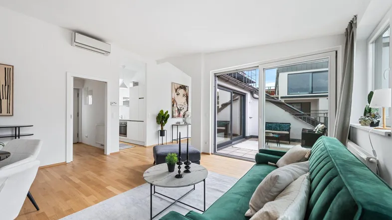 Helles Wohnzimmer mit Holzboden, moderner Einrichtung und Zugang zur Terrasse.