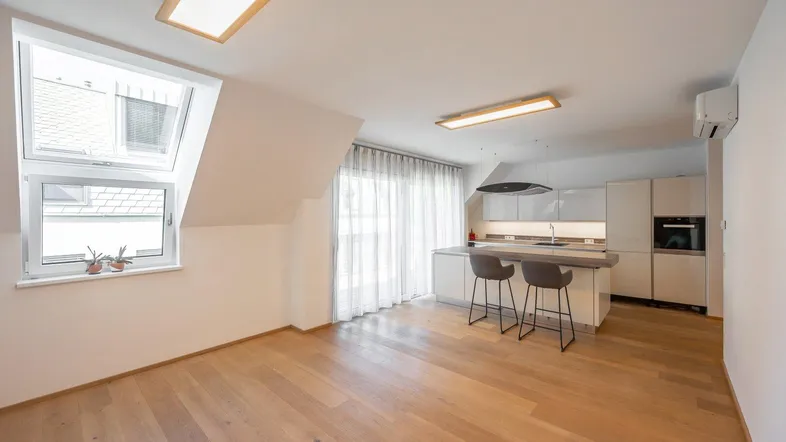Lichtdurchfluteter Wohn- und Kochbereich mit Dachfenstern und moderner Einbauküche.