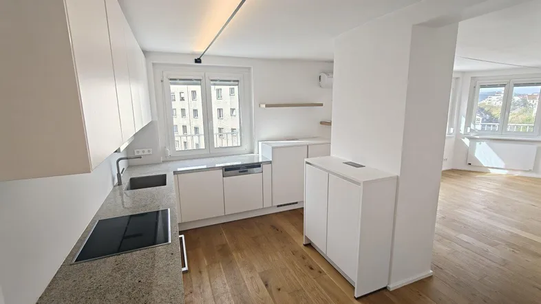 Moderne Küche mit weißen Schränken, Granitarbeitsplatte und Blick auf die Stadt.