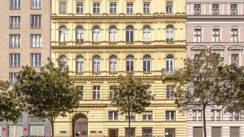 Klassisches Mehrfamilienhaus mit historischer Fassade und gepflegter Straßenansicht in urbaner Umgebung.