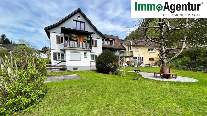 Mehrfamilienhaus mit großem Garten, Balkon und Bergblick in ländlicher Umgebung.