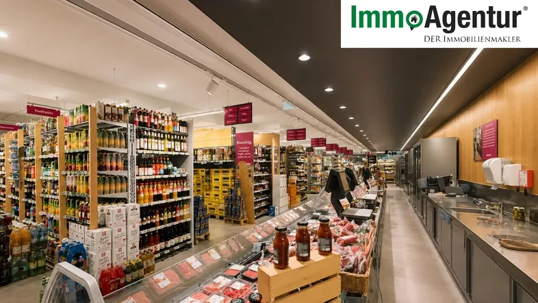 Innenansicht eines Supermarktes mit Kühltheken, Regalen voller Getränke und einer langen Theke.