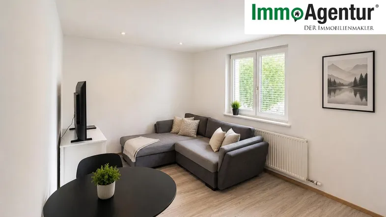 Helles Wohnzimmer mit modernem Sofa, Esstisch und Blick ins Grüne durch das Fenster.