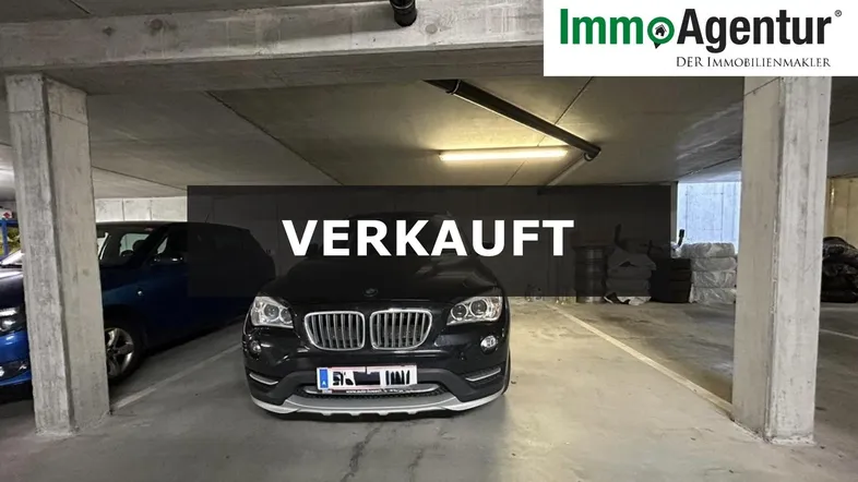Geräumige Tiefgarage mit Betonstützen und mehreren Parkplätzen, beleuchtet von Deckenleuchten.