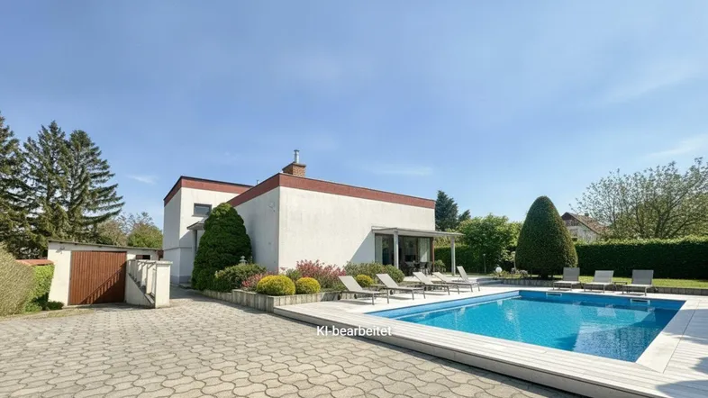 Modernes Haus mit großem Poolbereich, Holzdeck und Liegestühlen im Freien.