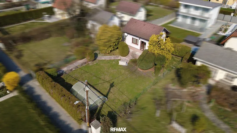 Luftaufnahme eines Einfamilienhauses mit großem Garten und gepflegter Außenanlage.