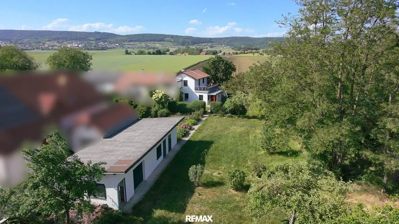 Luftaufnahme des Anwesens mit großem Garten und weitem Blick über die umliegende Landschaft.