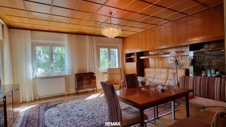 Geräumiger Wohn-Essbereich mit traditionellen Holzmöbeln, Teppich und Holzdeckenverkleidung.