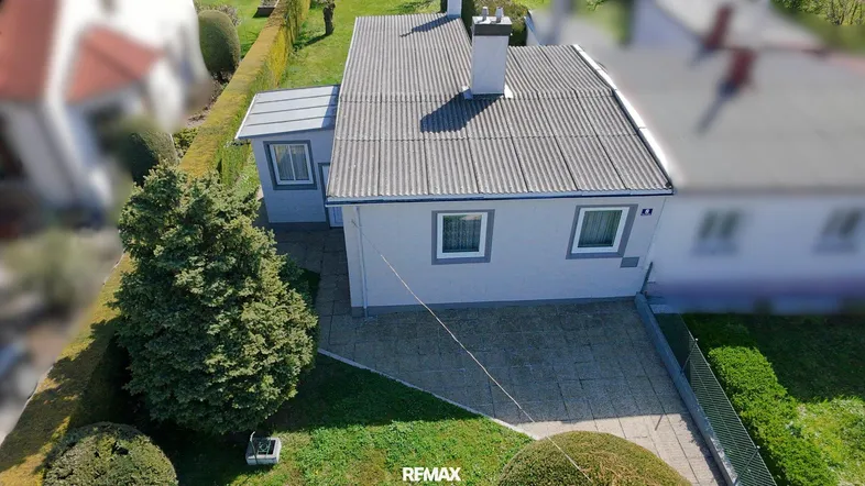 Draufsicht auf das Einfamilienhaus mit gepflegtem Vorgarten und Zufahrt.