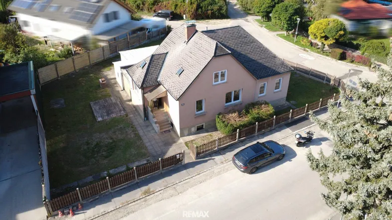 Luftaufnahme eines Einfamilienhauses mit Garten und angrenzender Straße in ländlicher Umgebung.