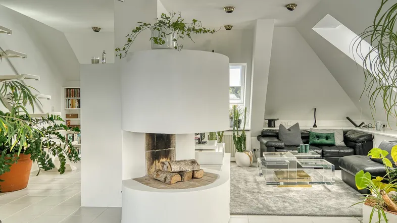Helles Dachgeschoss-Wohnzimmer mit modernem Kamin, weißen Fliesen und gemütlicher Sitzecke.