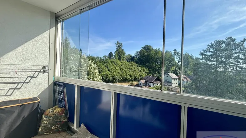 Verglaster Balkon mit weitem Blick ins Grüne und viel Tageslicht.