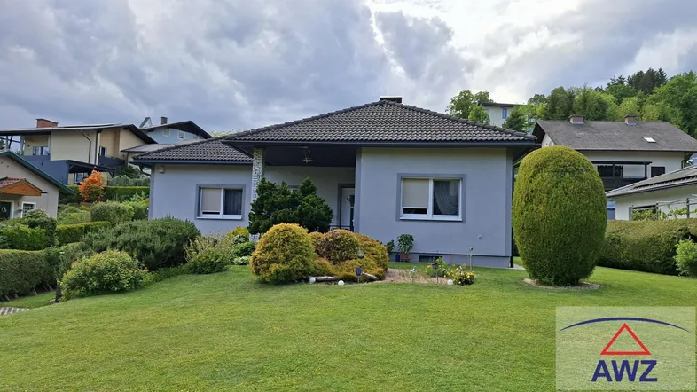 Einfamilienhaus mit gepflegtem Vorgarten und traditioneller Architektur unter bewölktem Himmel.