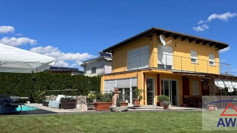 Gepflegter Gartenbereich mit Pool, Liegewiese und gemütlicher Terrasse am Haus.
