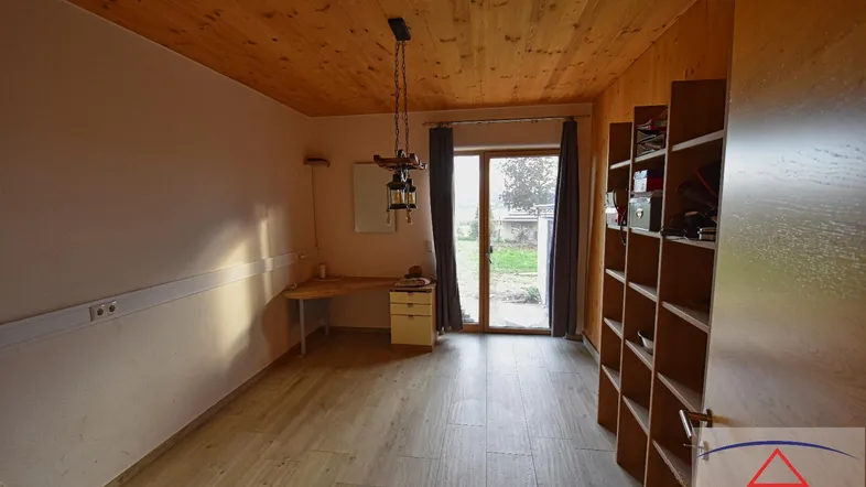 Heller Raum mit Holzdecke, Laminatboden und direktem Zugang zum Gartenbereich.