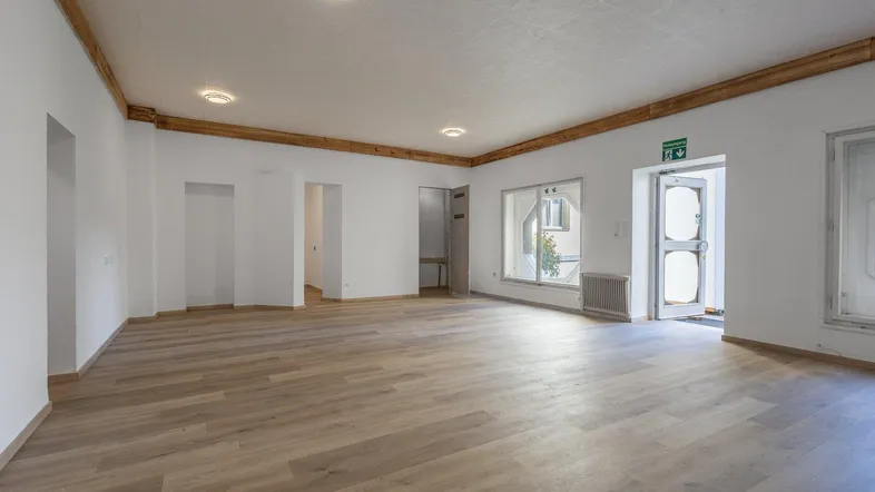 Großer, heller Raum mit Holzbalken und mehreren Fenstern, ideal für verschiedene Nutzungen.