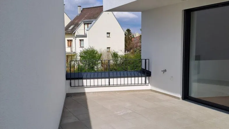 Geräumige, geflieste Terrasse mit modernem Geländer und Blick auf die Nachbarschaft.