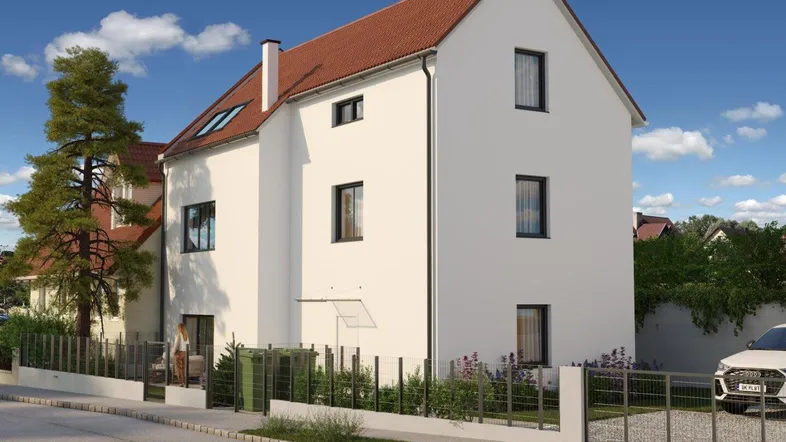 Moderne Neubaufassade mit weißem Putz, dunklen Fenstern und rotem Ziegeldach.