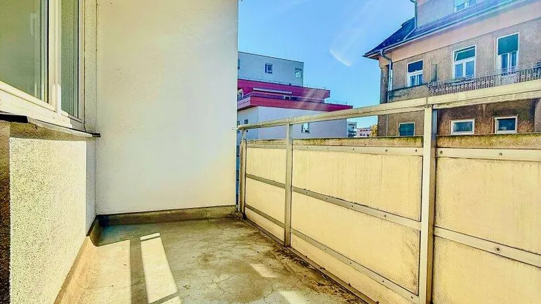 Heller Balkon mit Blick auf umliegende Gebäude und sonniger Ausrichtung.