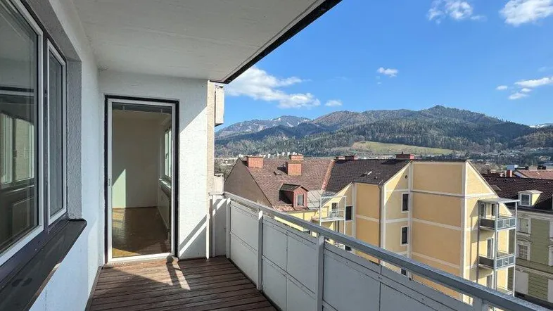 Geräumiger Balkon mit Holzboden und weitem Blick auf die umliegende Berglandschaft.