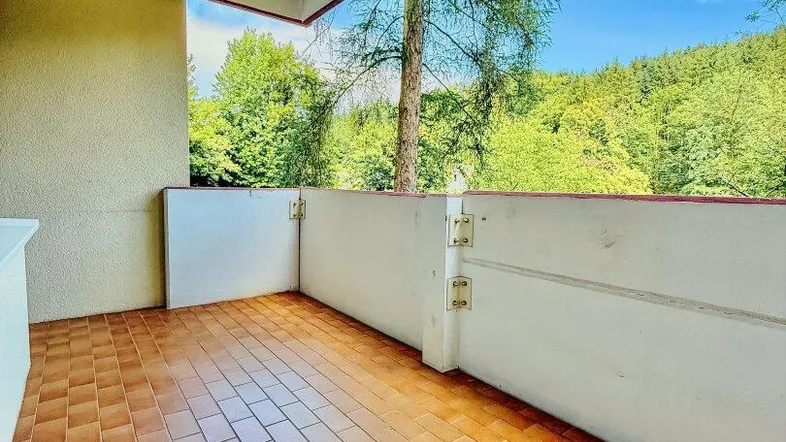 Geräumiger Balkon mit Terrakotta-Fliesenboden und weitem Blick ins Grüne.