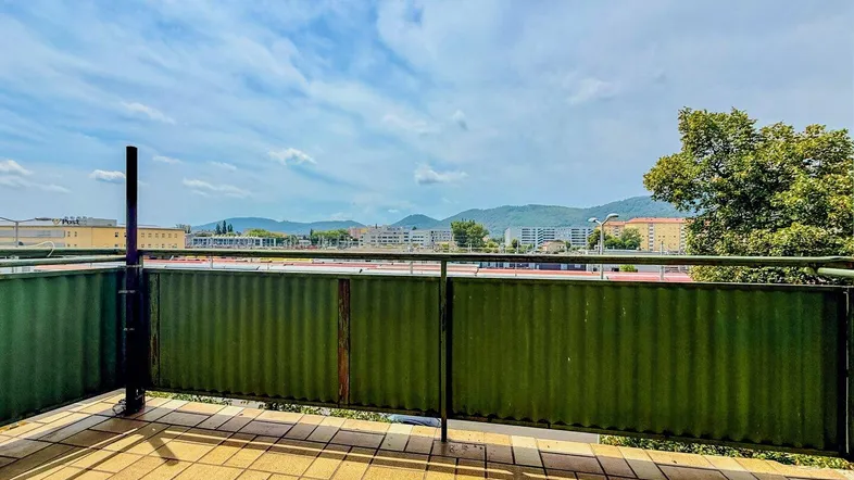 Geräumiger Balkon mit Fliesenboden und weitem Blick über die Stadt und die umliegenden Hügel.