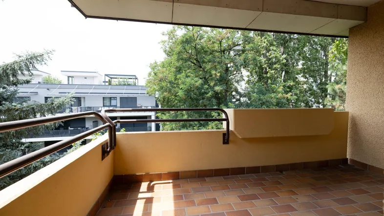 Geräumiger Balkon mit Fliesenboden und Blick ins Grüne, ideal zum Entspannen im Freien.