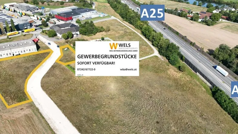 Luftaufnahme von Gewerbegrundstücken neben der Autobahn A25 mit Werbebanner.