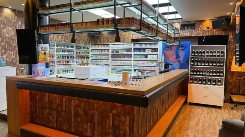Modernes Ladenlokal mit einer großen Theke, Regalen voller Produkte und integrierter Deckenbeleuchtung.