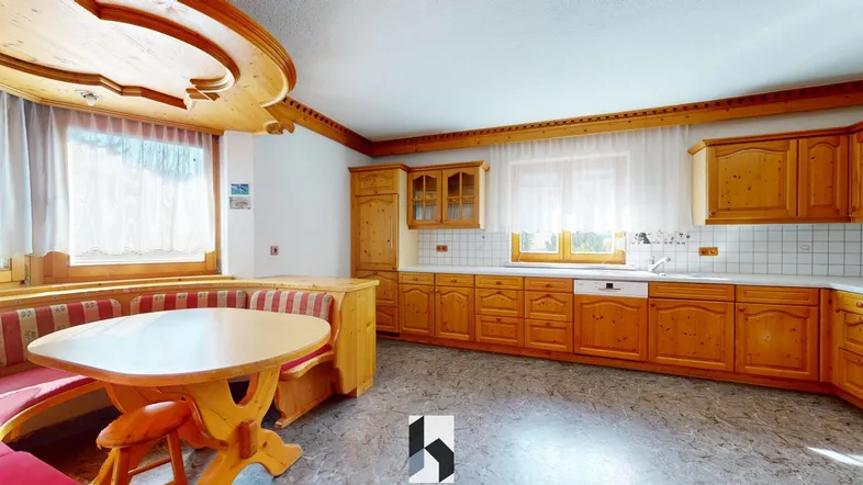 Gemütliche Wohnküche im Landhausstil mit Holzelementen und integrierter Essecke.