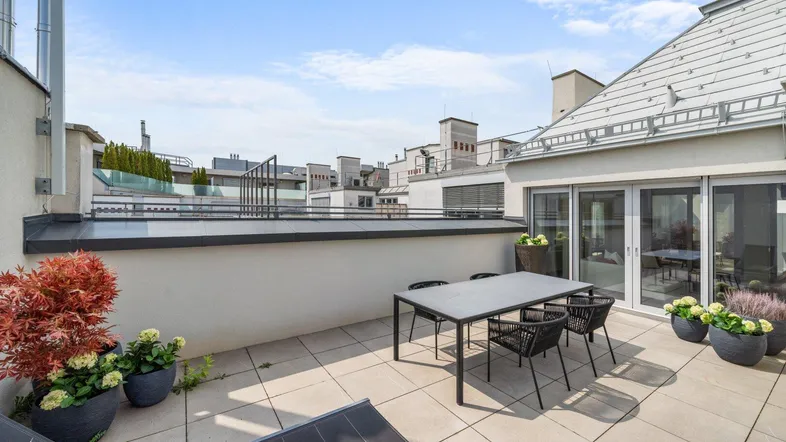 Große Dachterrasse mit modernen Gartenmöbeln und weitem Blick über die Stadt.