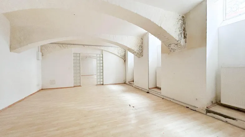 Geräumiger Innenraum mit gewölbten Decken und hellem Holzboden, bereit für individuelle Gestaltung.