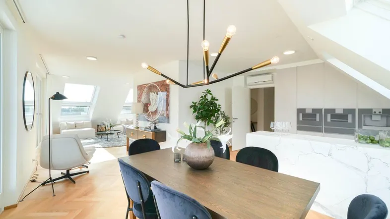 Helles, offenes Wohn- und Esszimmer mit moderner Einrichtung und integrierter Kücheninsel.