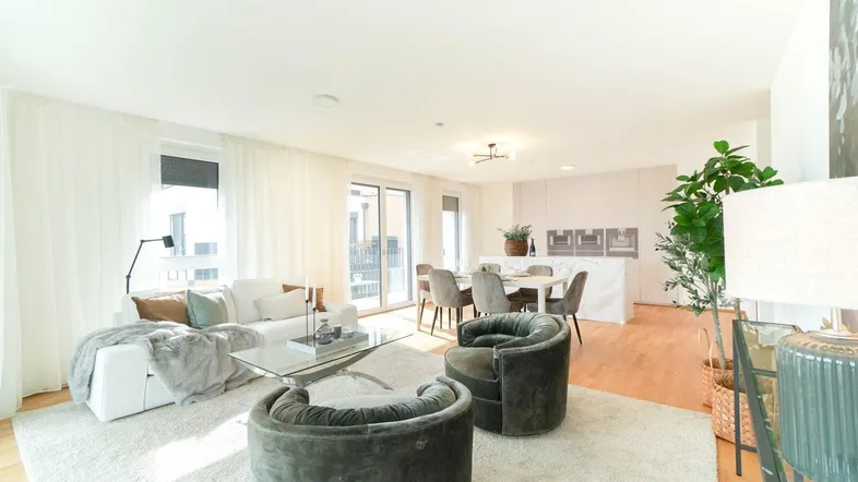 Helles, offenes Wohn- und Esszimmer mit modernem Interieur, Holzboden und Zugang zum Balkon.