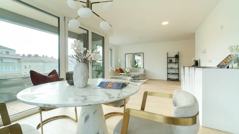 Helles, modernes Wohn- und Esszimmer mit Marmortisch, bequemen Sitzgelegenheiten und Zugang zum Balkon.