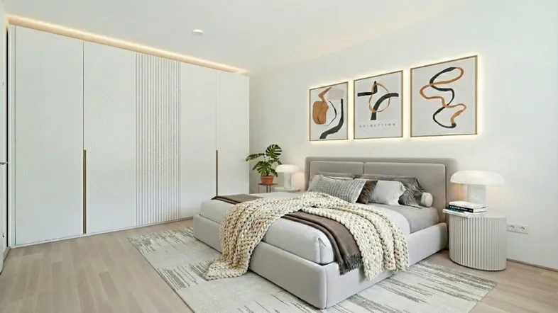 Modernes Schlafzimmer mit großem Bett, Einbauschränken und indirekter Beleuchtung an der Decke.