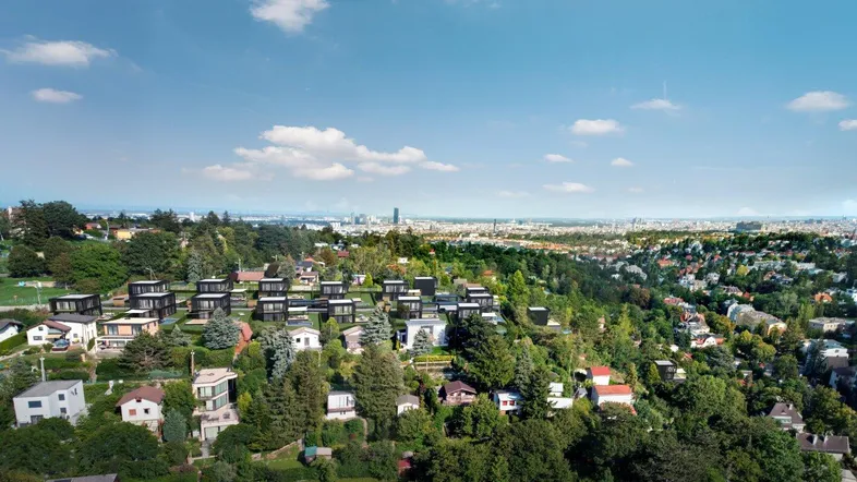 Luftaufnahme einer modernen Wohnsiedlung mit vielen Bäumen und weitem Blick auf die Stadt in der Ferne.