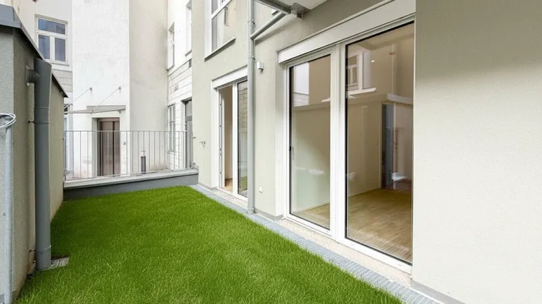 Kleiner privater Gartenbereich mit Rasenfläche und direktem Zugang zu den Innenräumen.