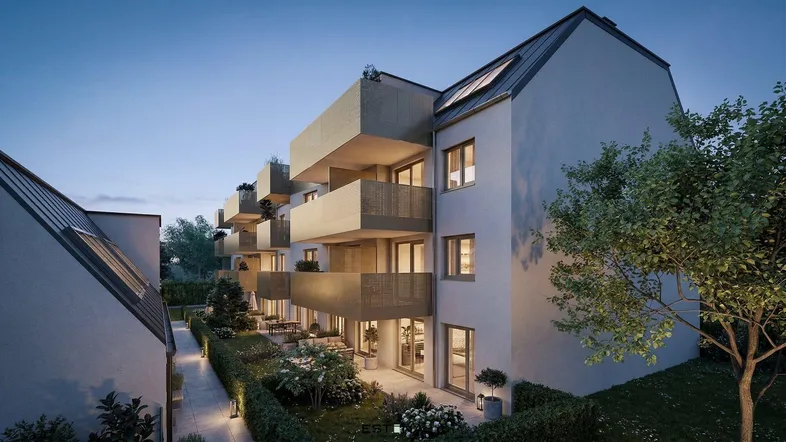 Moderne Wohnanlage bei Dämmerung mit Balkonen, Terrassen und begrünten Außenbereichen.