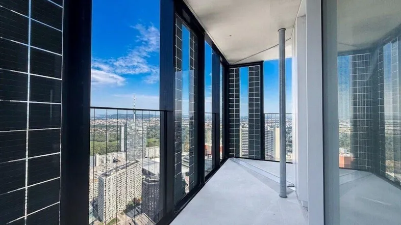 Geräumige Loggia mit beeindruckendem Stadtblick und modernen Glasfronten.